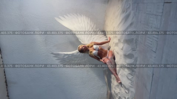 Graceful woman in underwear sitting on sand with angel wings backstage video. Стоковое видео, видеограф Гурьянов Андрей / Фотобанк Лори