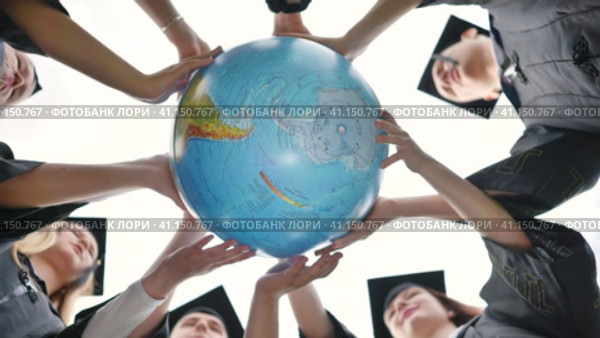 Graduating students twirl a geographic globe of the world in their hands. Стоковое видео, видеограф Mikhail Davidovich / Фотобанк Лори