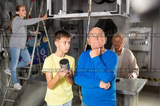 Grandson together with his grandfather solve the riddles of quest room. Стоковое фото, фотограф Яков Филимонов / Фотобанк Лори