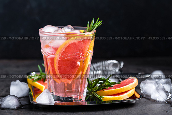 Grapefruit and fresh rosemary gin cocktail with juice, cold summer citrus refreshing drink or beverage with ice. Стоковое фото, агентство Ingram Publishing / Фотобанк Лори
