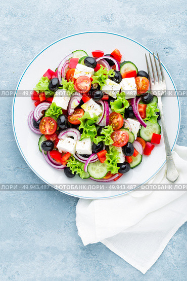Greek salad of fresh cucumber, tomato, sweet pepper, lettuce, red onion, feta cheese and olives with olive oil. Стоковое фото, агентство Ingram Publishing / Фотобанк Лори