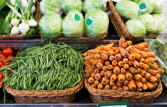 Green beans and carrots in wicker baskets on counter of vegetable store. Стоковое фото, фотограф Татьяна Яцевич / Фотобанк Лори