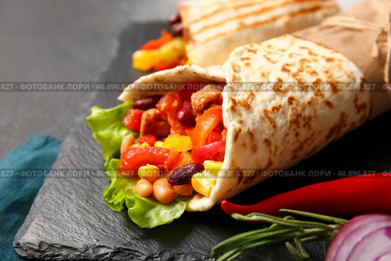 Грифельная тарелка с вкусным буррито на столе, крупным планом. Стоковое фото, фотограф Pixel_shot / Фотобанк Лори
