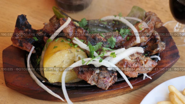 Grilled lamb ribs, potato and pepper decorated with fresh cut onion and greens. Стоковое видео, видеограф Яков Филимонов / Фотобанк Лори