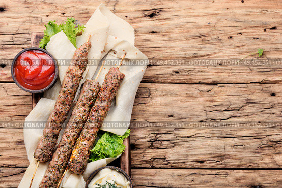 Grilled Lula kebab lamb with sauce.Traditional oriental cuisine.. Shish kebab on a stick. Стоковое фото, агентство Ingram Publishing / Фотобанк Лори