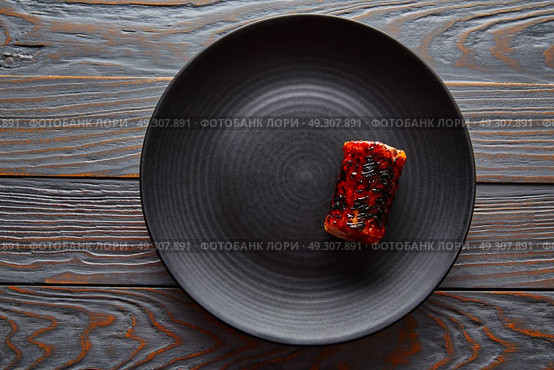 Grilled smoked eel on black plate modern cuisine gastronomy. Стоковое фото, агентство Ingram Publishing / Фотобанк Лори