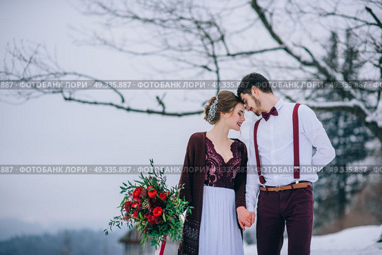 groom in a brown and bride in burgundy in the mountains Carpathians. Стоковое фото, агентство Ingram Publishing / Фотобанк Лори