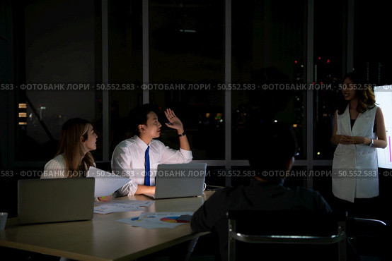 Group of broker international stock traders working actively at night in office, Everyone is striving for the team’s success. Стоковое фото, агентство Ingram Publishing / Фотобанк Лори