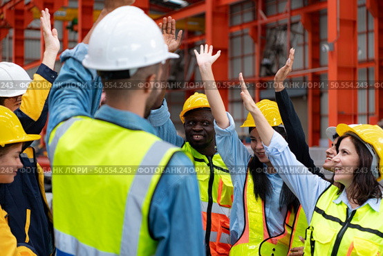 Group of factory workers in hardhats with arms raised celebrating success. Стоковое фото, агентство Ingram Publishing / Фотобанк Лори