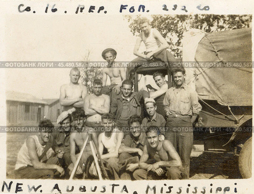 Группа мужчин в майках и брюках на фоне военного грузовика, надпись: New Augusta, Mississippi (город в округе Перри, штат Миссисипи, США), Вторая мировая война. Стоковое фото, фотограф WWII / Фотобанк Лори