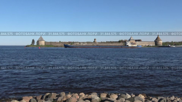 Грузовое судно проходит по Неве у крепости Орешек солнечным майским днем. Шлиссельбург, Россия (2019 год). Редакционное видео, видеограф Виктор Карасев / Фотобанк Лори
