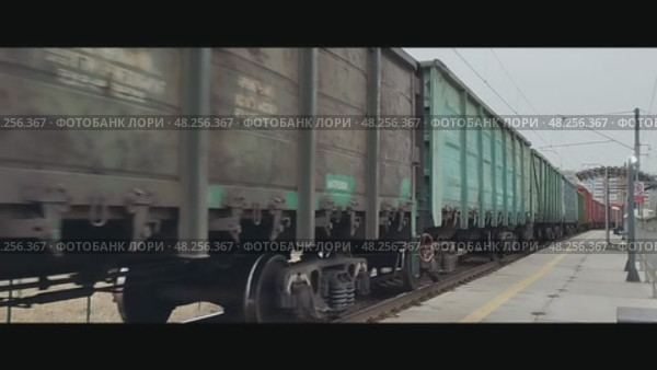 Грузовой поезд движется мимо остановочного пункта Синие Камни, перегон Аппаратная - Путёвка, Екатеринбург, Свердловская область. Редакционное видео, видеограф Алексей Иванов / Фотобанк Лори