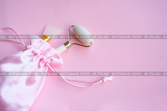 gua sha facce massager relaxing set on pink background. gua sha relaxing set on pink background. Стоковое фото, агентство Ingram Publishing / Фотобанк Лори