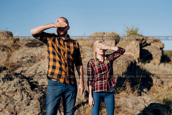 Guy and girl in caged shirts and trekking shoes on granite rocks. Стоковое фото, агентство Ingram Publishing / Фотобанк Лори