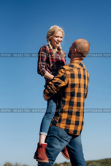 Guy and girl in caged shirts and trekking shoes on granite rocks. Стоковое фото, агентство Ingram Publishing / Фотобанк Лори