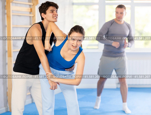 Guy and woman train to perform defense of strangling opponent, while learning self-defense. Стоковое фото, фотограф Яков Филимонов / Фотобанк Лори