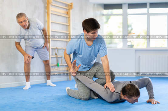 Guy practicing armlock in training bout during self-defence course. Стоковое фото, фотограф Яков Филимонов / Фотобанк Лори