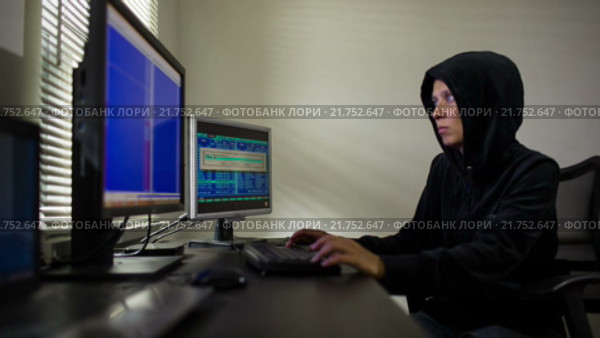 Хакер в черной кофте с капюшоном крадет информацию. Стоковое видео, видеограф Анатолий Типляшин / Фотобанк Лори