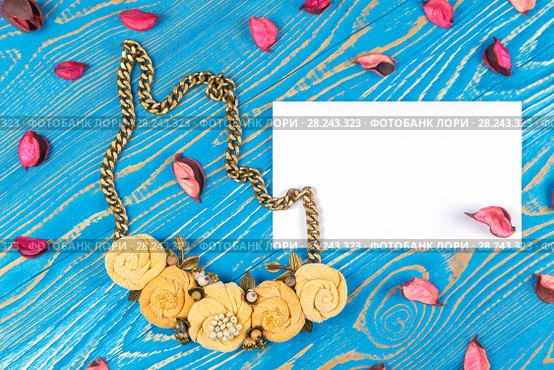 Handmade necklace consisting of five flowers and a greeting card with congratulations on a blue wooden background. Стоковое фото, фотограф Олег Белов / Фотобанк Лори
