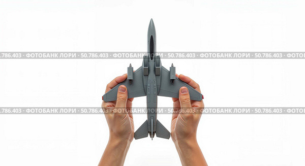 Hands holding a gray model airplane against a white background. Стоковое AI-изображение, AI-художник Ольга Невская / Фотобанк Лори