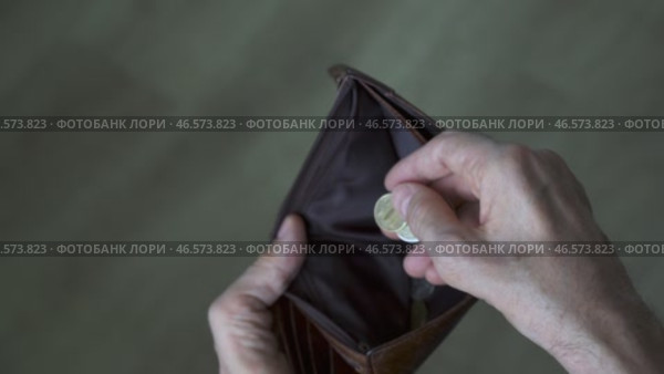 Hands of an elderly man with the last coin in an empty wallet. Стоковое видео, видеограф Владимир Федоров / Фотобанк Лори
