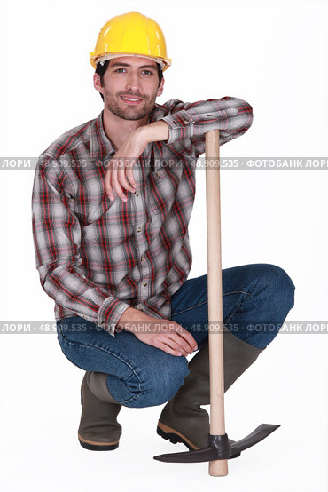 handsome bricklayer with arm resting on pickaxe. Стоковое фото, агентство Ingram Publishing / Фотобанк Лори
