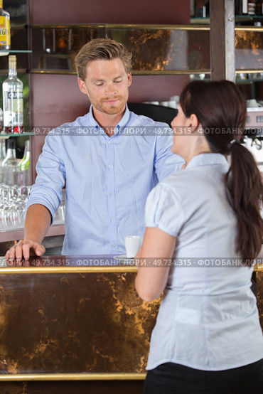 handsome waiter serving coffees to customer at the coffee shop. Стоковое фото, агентство Ingram Publishing / Фотобанк Лори