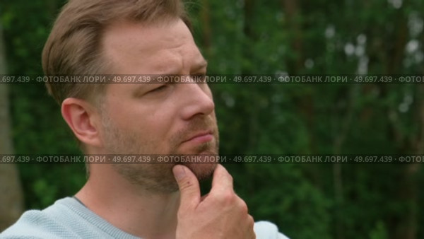 Handsome young man standing outdoors. Male thinking looking around feel happy, calm and serious. Green park background. Guy business employer, businessman manager inspired in nature. Diversity People. Стоковое видео, видеограф Марина Демидюк / Фотобанк Лори