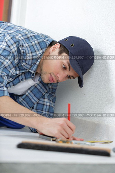 handyman working on floor in new home - construction concept. Стоковое фото, агентство Ingram Publishing / Фотобанк Лори