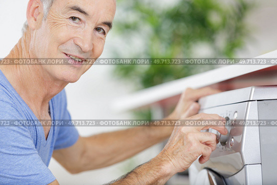 happy mature man doing the laundry chores. Стоковое фото, агентство Ingram Publishing / Фотобанк Лори