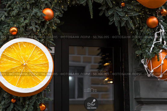 Happy New Year 2026. Mandarins in a string bag and Christmas tree decorations on the streets of Moscow. The concept of preparing decorations and ornaments for Christmas. Стоковое фото, фотограф Photojuli / Фотобанк Лори