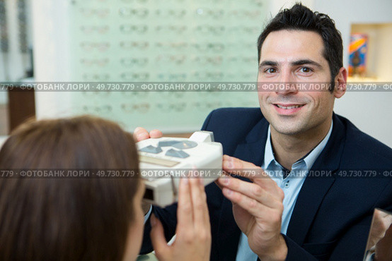 happy optician examining patients eyes. Стоковое фото, агентство Ingram Publishing / Фотобанк Лори