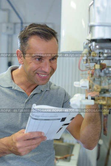 happy plumber repairing an hot-water heater. Стоковое фото, агентство Ingram Publishing / Фотобанк Лори
