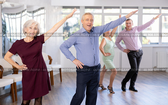 Happy senior woman and man enjoying active boogie-woogie dance in studio. Social dancing concept. Стоковое фото, фотограф Яков Филимонов / Фотобанк Лори