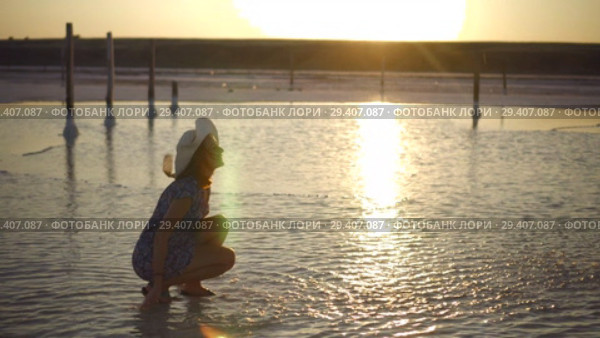 happy smiling girl enjoying sun, sprinkles salt water of lake in rays of sunset. Стоковое видео, видеограф Ирина Мойсеева / Фотобанк Лори