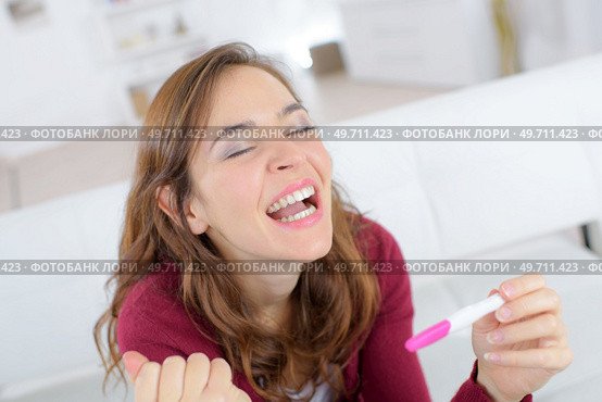 happy woman holding pregnancy test. Стоковое фото, агентство Ingram Publishing / Фотобанк Лори