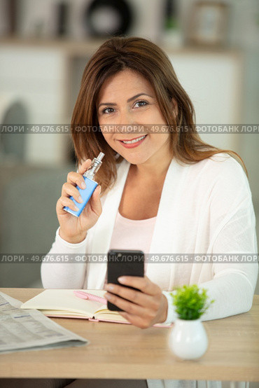 happy woman is smoking an electronic cigarette. Стоковое фото, агентство Ingram Publishing / Фотобанк Лори