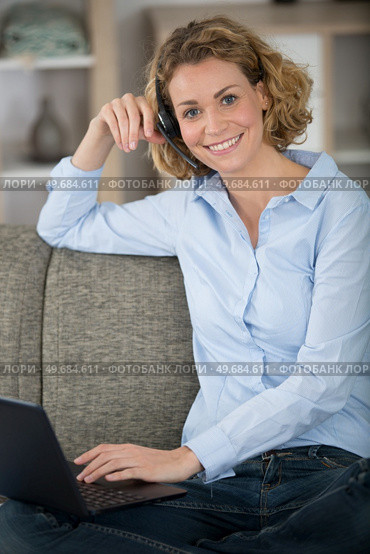 happy woman sitting on couch in living room. Стоковое фото, агентство Ingram Publishing / Фотобанк Лори