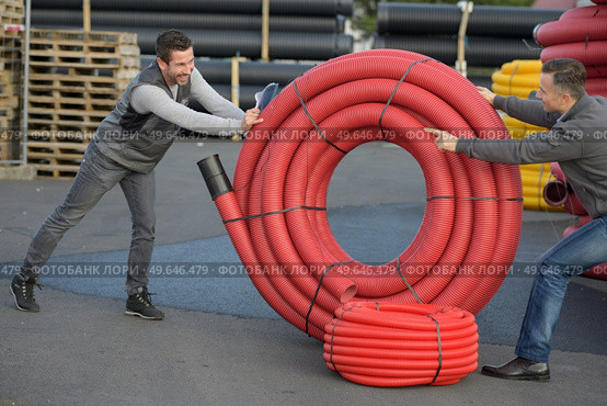 happy workers moving heavy pipes outdoors. Стоковое фото, агентство Ingram Publishing / Фотобанк Лори
