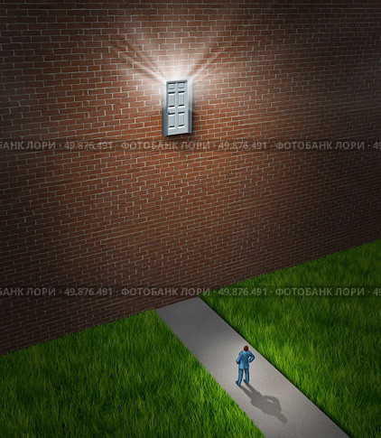 Hard goals as a business concept for opportunities that are out of reach as a businessman standing in front a huge brick wall from a house or building with a high unaccessible door that is shinning light. Стоковое фото, агентство Ingram Publishing / Фотобанк Лори