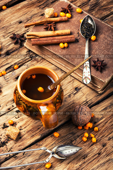 healthy tea with sea-buckthorn. teacup with healing berry tea with sea-buckthorn on retro background. Стоковое фото, агентство Ingram Publishing / Фотобанк Лори
