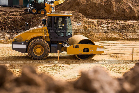 Heavy machinery for excavation and landscaping. Close-up of a road roller on a construction site in the sand. Excavation and road construction. Стоковое фото, фотограф Photojuli / Фотобанк Лори