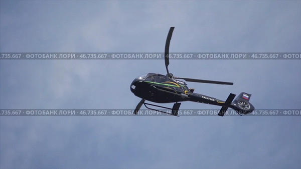 Helicopter hovering against bright sunny and cloudy sky. Стоковое фото, фотограф David Kashakhi / Фотобанк Лори