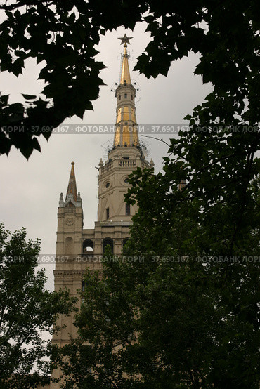 High-rise building on the Barrikadnaya Metro (subway) station of Moscow. Summer sunlight on the grey sky. One of Stalinist skyscrapers. Trees on foreground. (2005 год). Редакционное фото, фотограф Alexey Rezvykh / Фотобанк Лори