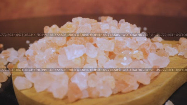 Himalayan pink salt in a wooden is used to flavor food. Due mainly to marketing costs, pink Himalayan salt is up to twenty times more expensive than table or sea salt. Loop video. Стоковое видео, видеограф Андрей Армягов / Фотобанк Лори