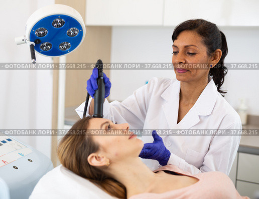 Hispanic woman beautician doing needle-free mesotherapy for young woman. Стоковое фото, фотограф Яков Филимонов / Фотобанк Лори