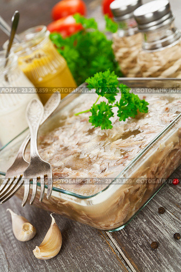 Холодец из свинины и курицы в стеклянной форме и приправы на обеденном столе. Стоковое фото, фотограф Надежда Мишкова / Фотобанк Лори