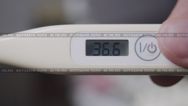 Home electronic thermometer indicates a temperature of 36.6 degrees Celsius. Стоковое видео, видеограф Strunov David / Фотобанк Лори