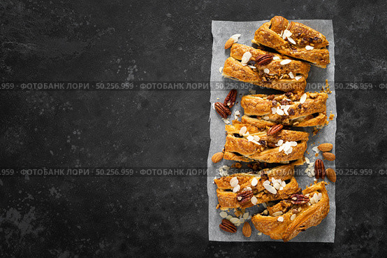 Homemade chocolate puff pastry braided strudel, pie with pecan nuts and almond, top view. Стоковое фото, агентство Ingram Publishing / Фотобанк Лори