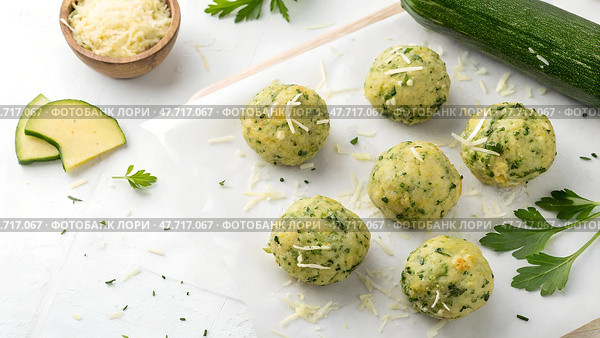 Homemade zucchini and herb dumplings prepared on a clean kitchen surface with fresh ingredients nearby. Стоковое AI-изображение, AI-художник Анна Сивакова / Фотобанк Лори